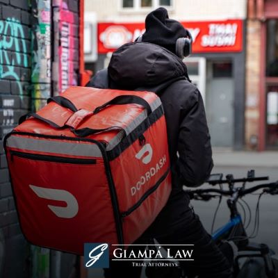 A person on a bike carrying a DoorDash delivery on their back