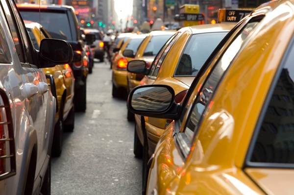 Rows of yellow taxis and other vehicles sit in dense, stop-and-go traffic on a New York City street, a high-risk environment where smartphone distractions frequently lead to rear-end collisions and city accidents.